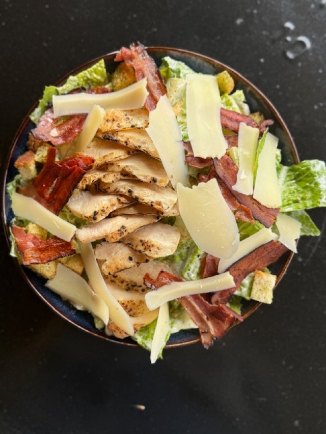 Caesar s grilovaným kuřecím prsem, slaninou, originálním dresingem z ančoviček, krutóny a sýrem Grana Padano